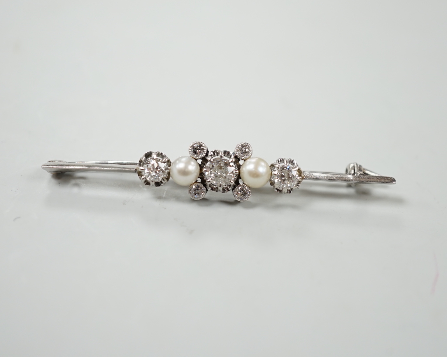 A white metal, diamond and cultured pearl cluster set bar brooch, 52mm, gross weight 6.2 grams.